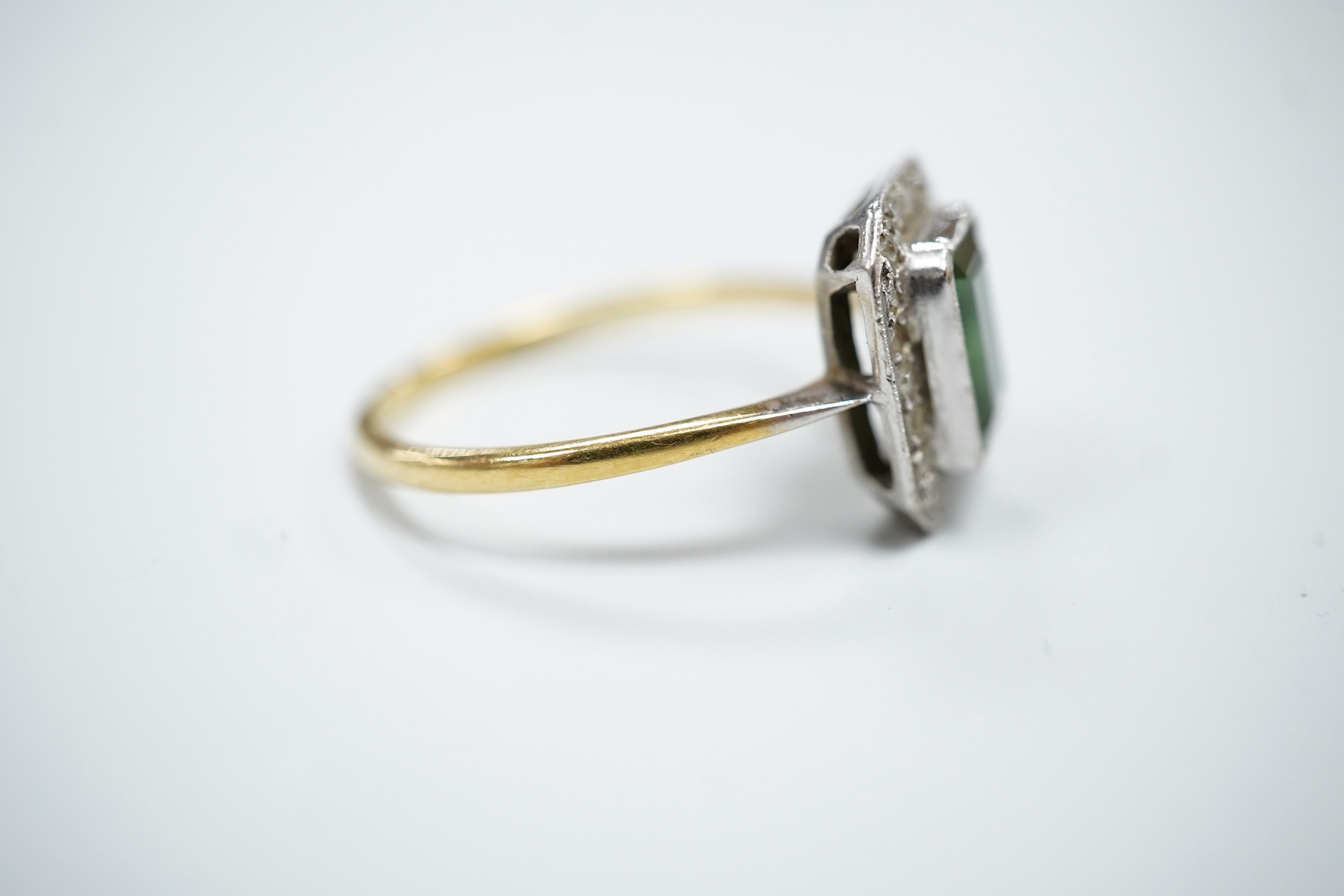 A yellow metal, green tourmaline and diamond set octagonal cluster ring, in a millegrain setting, size R, gross weight 3 grams.